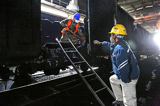 马头热电公司燃料质检部接卸班邢涛指挥协调卸煤队人员清卸车厢内的冻煤 - 副本.jpg