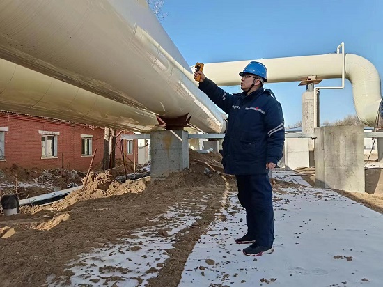 王永胜在用测温枪测量管道温度.jpg