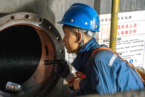 检修团队在凝汽器人孔门处监护内部铜管查漏作业.jpg